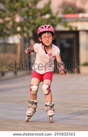 BEIJING-JULY 10, 2015. Girl practicing inline skating. Although Ping-Pong, basketball and badminton are China\'s top sports, last decade inline skating became increasingly popular among Chinese youth.