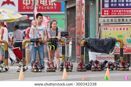 BEIJING-JULY 24, 2015. Young couple watching inline skating. Although Ping-Pong, basketball and badminton are China\'s top sports, last decade inline skating became increasingly popular among youth.