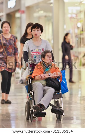 BEIJING-AUGUST 19, 2015. Woman with elder mother at shopping mall. China\'s elderly population (60 or older) is about 128 million, 10% of its population, China will have 400 million elderly by 2050.