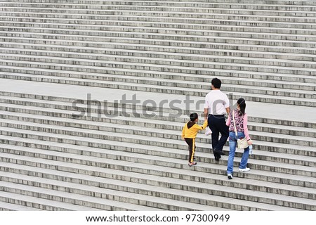XIAN-MAY 22, 2009. A family\'s way up on a staircase on May 22, 2009 in Xian. Since 1979 China\'s government retains a one-child policy. Families are allowed to have only one child or risk steep fines.