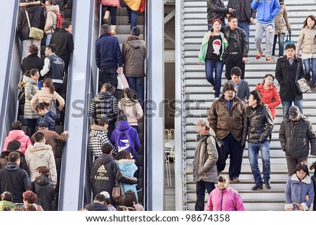 BEIJING - MARCH 10, 2012. Crowd on escalator and stairs in Beijing on March 10, 2012. With just over 1.3 billion people (1,339,724,852 as of 2010 census), China is the world\'s most populous country.