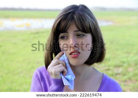 Women's tears. The girl wipes her tears with a handkerchief. These are tears from spring allergies or some misfortune.