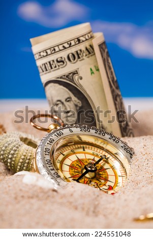 Sea Hedgehog shells  and compass  and dollar money on  sand and blue sky Background