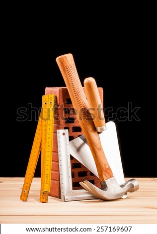builder  tools on black background and wooden table