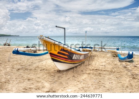 Kuta, Bali, Indonesia - Dec 25 2014: Boats stand by at the beach of Kuta, Bali island. Bali island is the most famous island in Indonesia