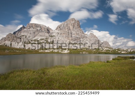 The Paterno mount and lake Dei Piani, near the famous Tre Cime di Lavaredo (Drei Zinnen) in a day of Summer with blue sky and clouds, Dolomites, Italy