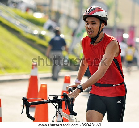 KUALA LUMPUR - SEPT 24: An unidentified participant cycles after run 5km at Malakoff University Duathlon Series 2011, on September 24, 2011 in Kuala Lumpur, Malaysia