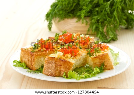 Fried toast with cheese and red caviar, greens