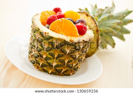 salad of pineapple, oranges and other fruits in a pineapple