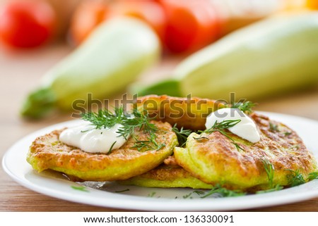 zucchini pancakes on a plate with greens
