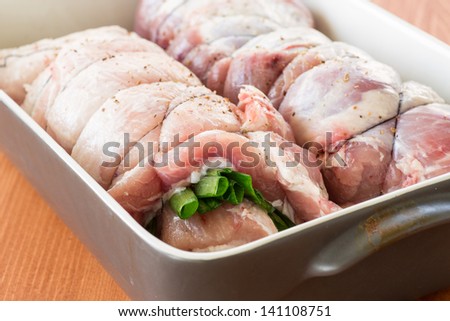 raw meat with green onions twisted to roll in the shape of the baking
