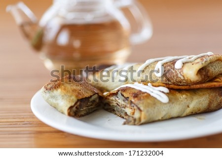 pancakes stuffed with mushrooms and cabbage with sour cream