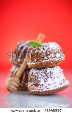 sweet honey muffins in powdered sugar on red background