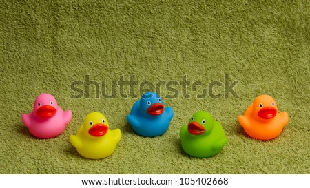 Rubber ducks isolated on a green towel, with room for text