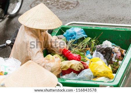 DA LAT, VIETNAM - JULY 28: Government worker separates the waste on the street for recycling. Pollution is a big problem in Vietnam nowadays. on july 28, 2012 in DA LAT, Vietman