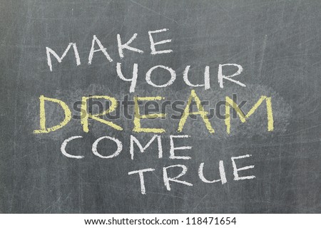 Make your dream come true - motivational slogan handwritten with white chalk on blackboard