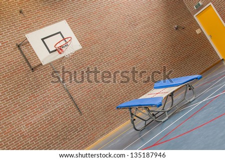Interior of a gym at school, jumping high at the basket