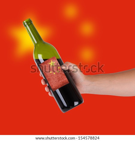 Hand holding a bottle of red wine, label of China, isolated on white,