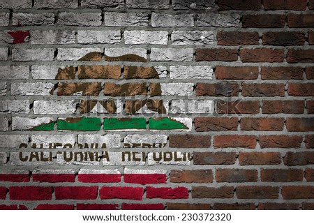 Very old dark red brick wall texture with flag - California