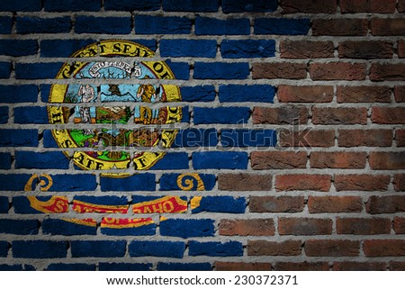 Very old dark red brick wall texture with flag - Idaho