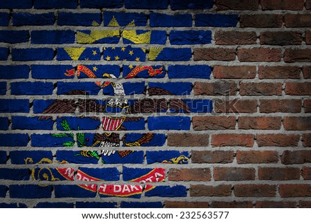 Very old dark red brick wall texture with flag - North Dakota