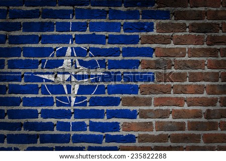 Very old dark red brick wall texture with flag - NATO