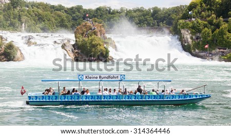 RHEINFALLS, SWITZERLAND - JULY 25, 2015:Boat with tourists at the biggest waterfalls of Europe in Schaffhausen, Switzerland. They are 150 m (450 ft) wide and 23 m (75 ft) high on july 25, 2015.