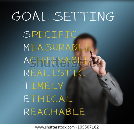 business man writing  concept of smarter goal or objective setting - specific - measurable - achievable realistic - timely - ethical - reachable