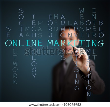 business man writing online marketing  concept by crossword of relate word such as internet, technology, advertising, seo, website, media, etc.