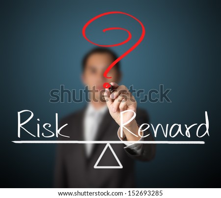 business man writing question with risk compare to reward on balance bar
