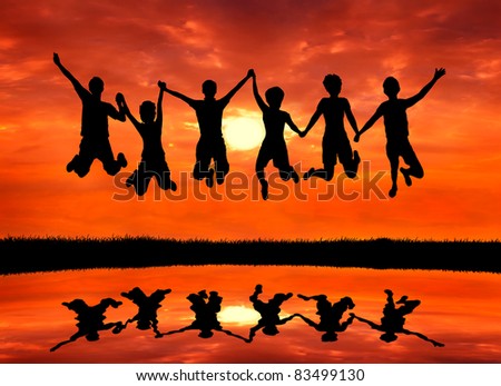 group of happy freedom men and women friends jumping with joy at sunrise silhouetted