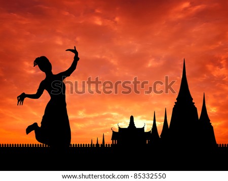 thai dance perform by young woman silhouetted with  temple in thailand background