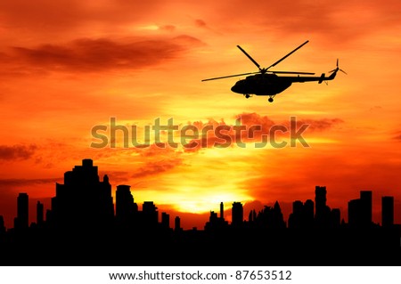 silhouette of helicopter fly over urban building