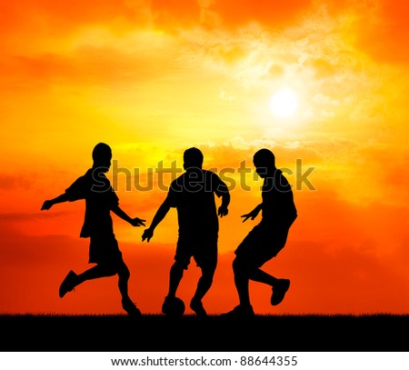 three man soccer player playing with ball during sunset silhouetted