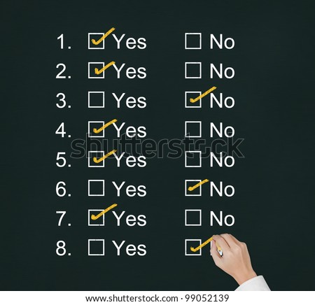 hand answering questions by make mark at yes or no boxes on chalkboard