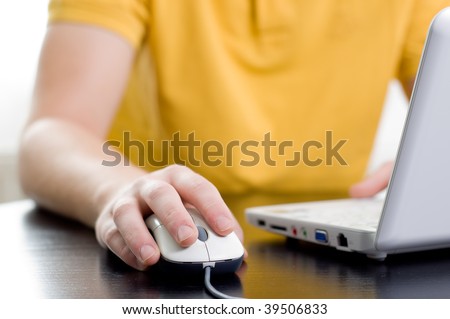 Man in yellow shirt with his right hand on the mouse (shallow DOF)