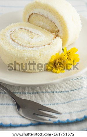 The vanilla roll cake on the blue stripes clothes,yellow small flower