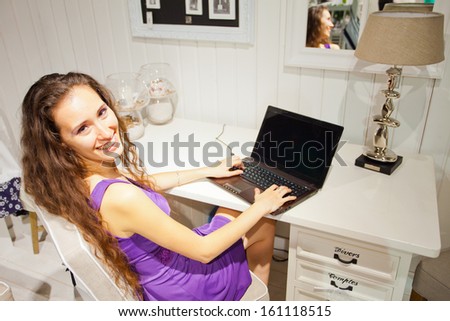 Young attractive woman working on laptop through wireless technology in Home, interior, living room
