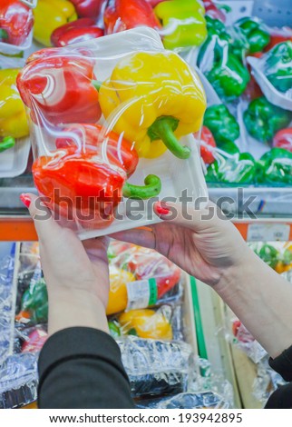 Image of packaged bell pepper with woman hand in the supermarket