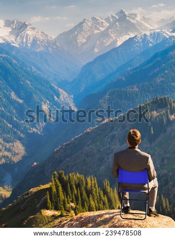 businessman at the top of mountain, thinking about future plans.