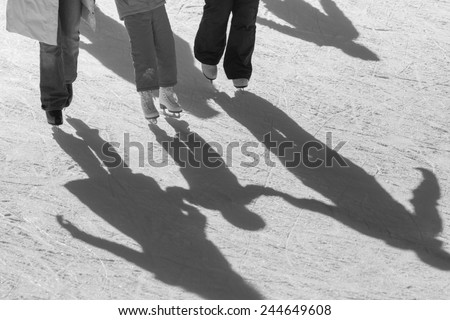 shadow background of family on the ice, they hold child's hands