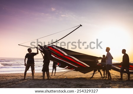 INDONESIA - AUGUST 17: Indonesian boys going to fly a kite near the coast AUGUST 17, 2014. During the Indonesian holidays, there are kite flying competitions which is a national tradition.