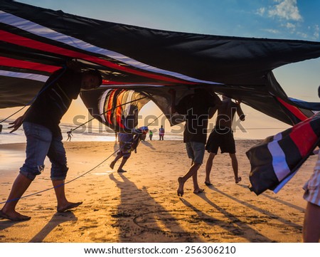 INDONESIA - AUGUST 17: Indonesian boys going to fly a kite near the coast on the background of clear sky  AUGUST 17,2014. INDONESIA. During the Indonesian holidays, there are kite flying competitions.