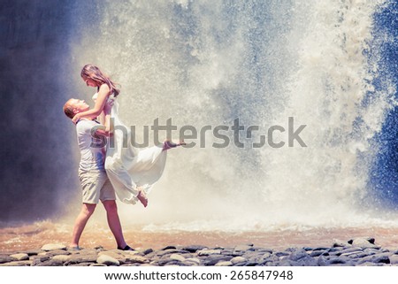 couple travel near the big waterfall