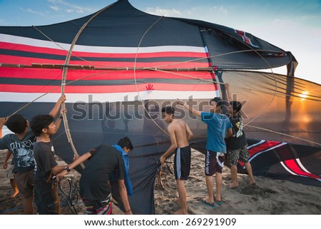 INDONESIA - AUGUST 17: Indonesian boys going to fly a kite near the coast on the background of clear sky  AUGUST 17, 2014. INDONESIA. During Indonesian holidays, there are competitions of flying kite