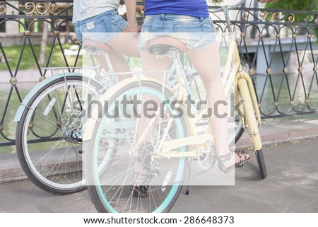 closeup beautiful sexy women dressed in short shorts travel by city vintage bicycle at summer time. There is a square white frame for any text and label or copy space