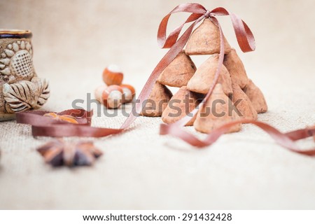 Chocolate truffles candies and vintage glass of milk or cream on background of burlap bag texture and decorative ribbon, selective focus and old style for chocolate day, copy space for any text