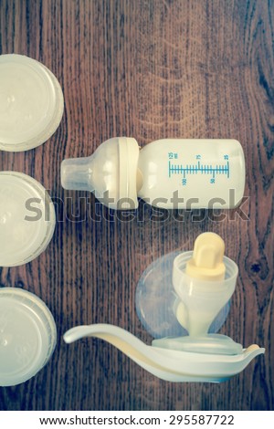 Background of manual breast pump and baby bottle with milk. Mothers breast milk is most healthy food for newborn baby. Top view. Monochromatic and instagram edition with copy space