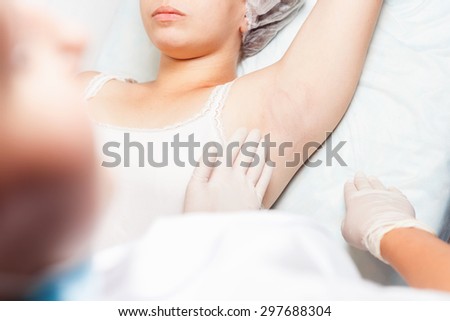 Professional woman at spa beauty salon doing epilation armpits using sugar - sugaring. You can see her smooth and hair free armpits after hair removal