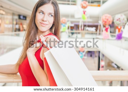 Closeup big bags fashion woman holding at shopping center, she dressed in red dress. There is a large copy space for text, label and design
